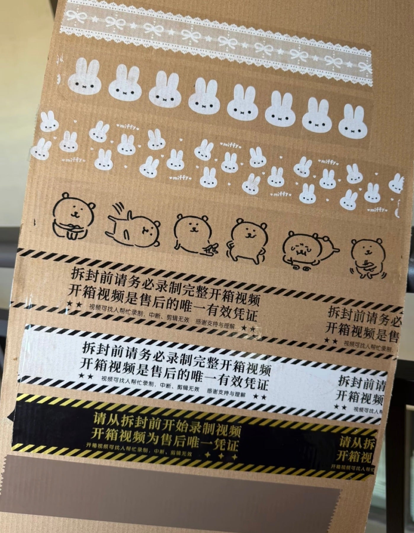 Real printed warning and cartoon tape samples applied to a carton