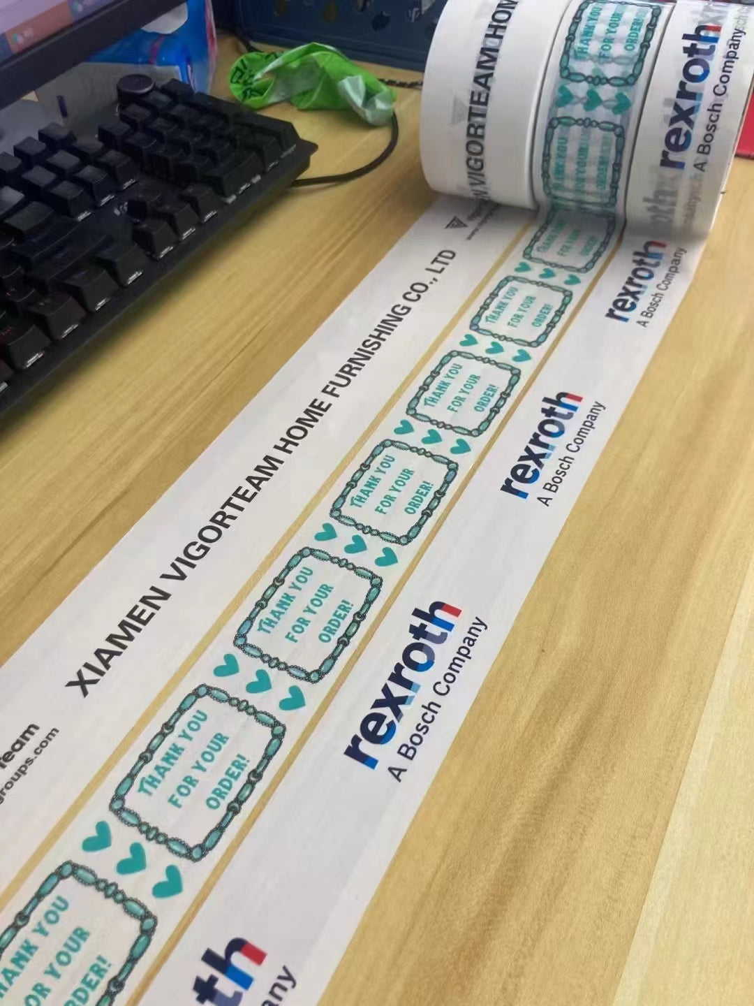 Real custom printed BOPP packing tape samples with company logos and thank-you message