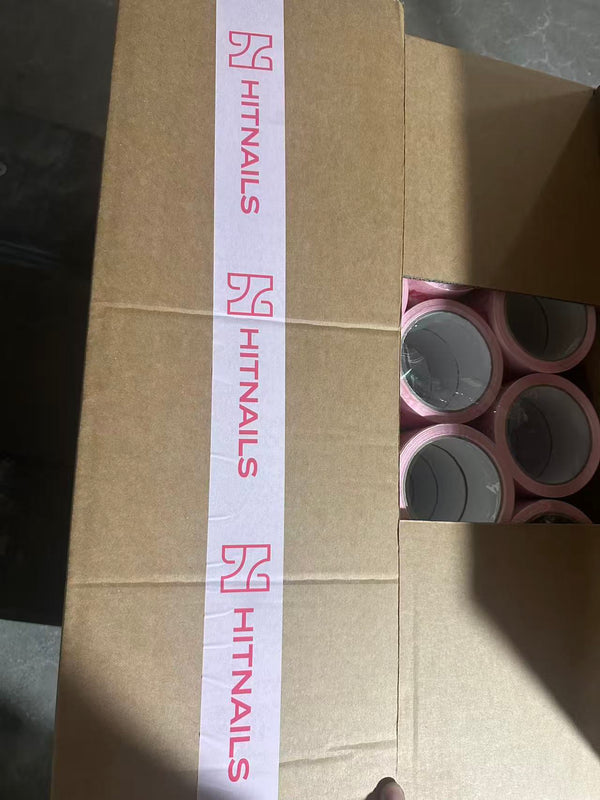 White packing tape with a customer's pink logo sealing a kraft shipping carton; rolls of the same tape are visible inside the box